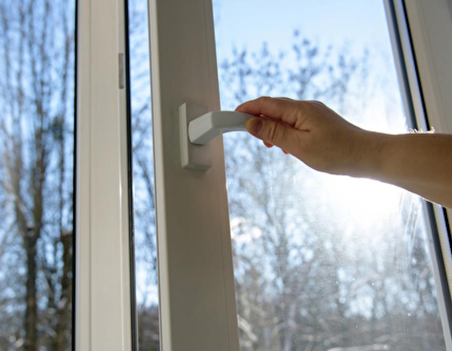 Hand öffnet ein Fenster, durch das Sonnenlicht und ein klarer Himmel sichtbar sind. Hand öffnet ein Fenster, durch das Sonnenlicht und ein klarer Himmel sichtbar sind.