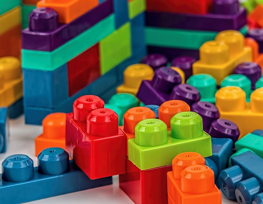 Bunte Klemmbausteine liegen durcheinander auf einer Platte Bunte Klemmbausteine liegen durcheinander auf einer Platte