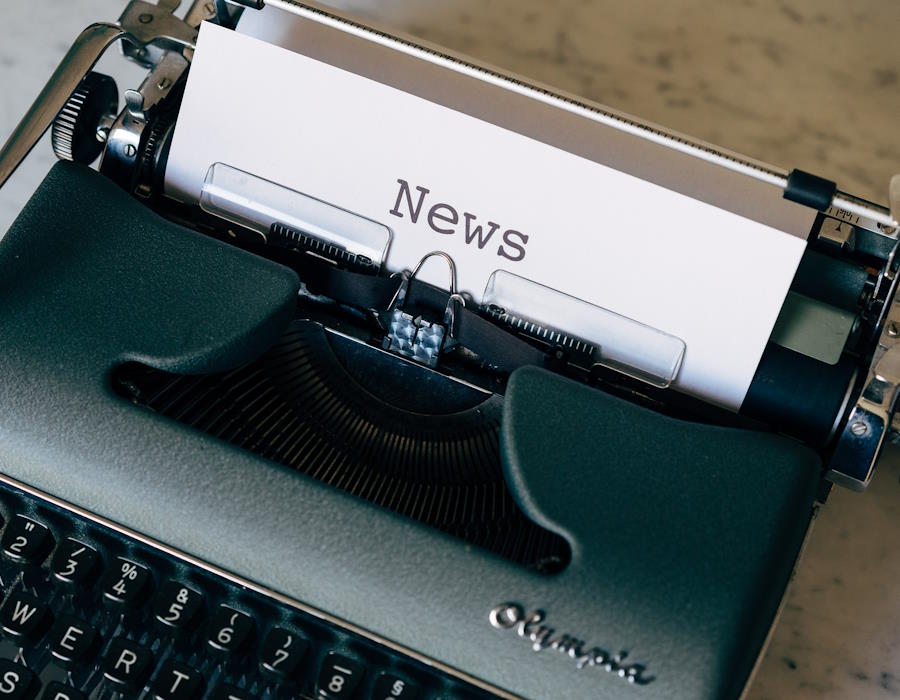 Eine alte Schreibmaschine mit einem eingelegten weißen Blatt. Auf dem Blatt steht das Wort News Eine alte Schreibmaschine mit einem eingelegten weißen Blatt. Auf dem Blatt steht das Wort News