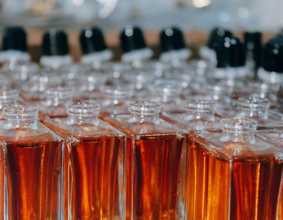 Symbolbild: Viele aufgereiht Parfumflakons aus Glas mit einer farbigen Flüssigkeit. Duftstoffe können die Innenraumluft belasten. Symbolbild: Viele aufgereiht Parfumflakons aus Glas mit einer farbigen Flüssigkeit. Duftstoffe können die Innenraumluft belasten.