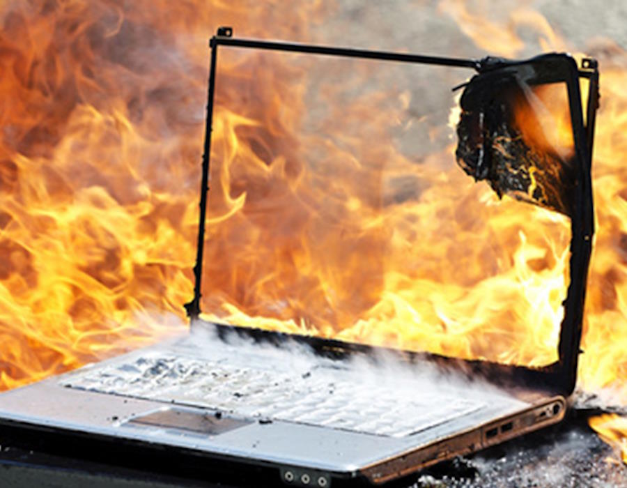 Symbolbild: In Flammen stehender Laptop. Flammschutzmittel hemmen die Entflammbarkeit von Materialien und Geräten.