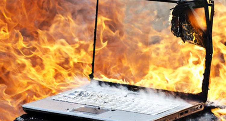 Symbolbild: In Flammen stehender Laptop. Flammschutzmittel hemmen die Entflammbarkeit von Materialien und Geräten.