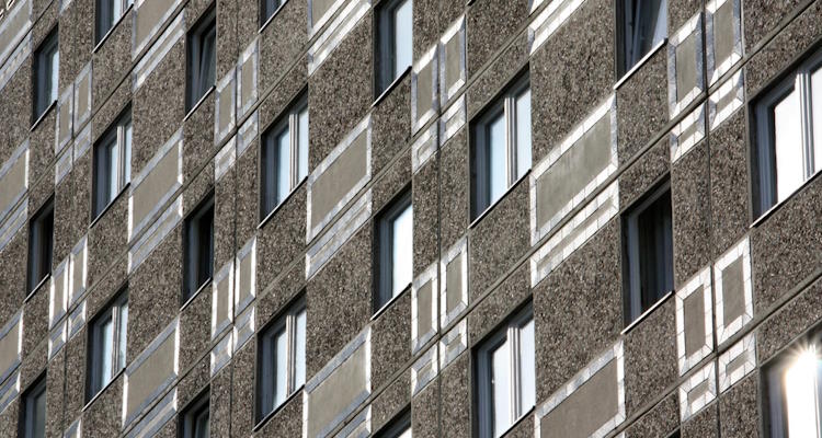 Symbolbild: Plattenbau mit vielen Fenstern. Alte Dehnungsfugen können PCB enthalten, das auch den Innenraum belastet. 