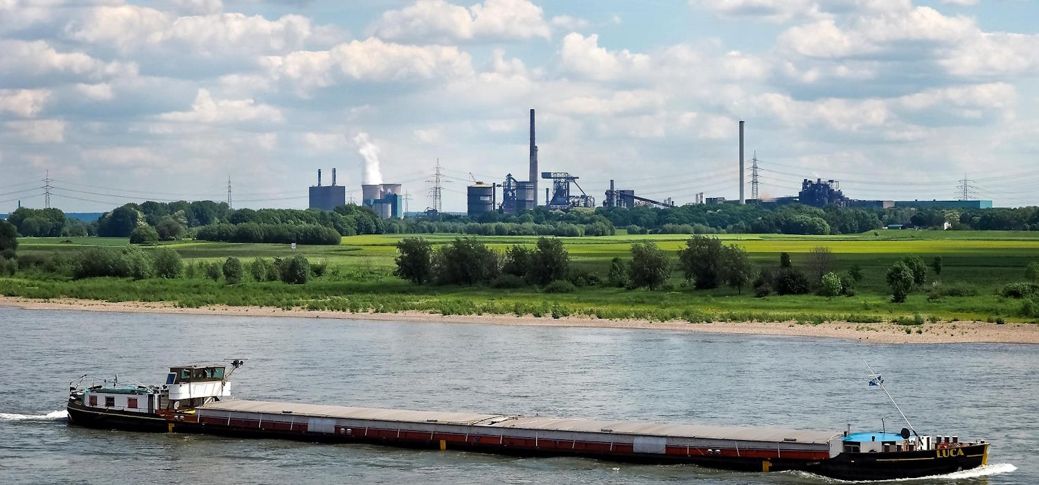 Frachtschiff auf dem Rhein. Im Hintergrund sind Industrieanlagen des  Chempark Krefeld-Uerdingen zu sehen.