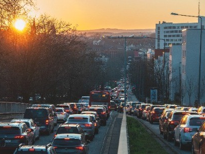 Das Bild zeigt einen Fahrradfaher auf einer Kreuzung bei Sonnenuntergnag